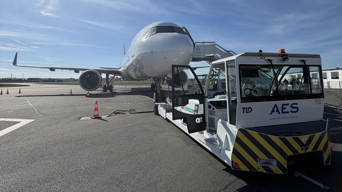 Tracteur de piste devant un avion de ligne sur l'aire de stationnement de l'aéroport Paris-Beauvais